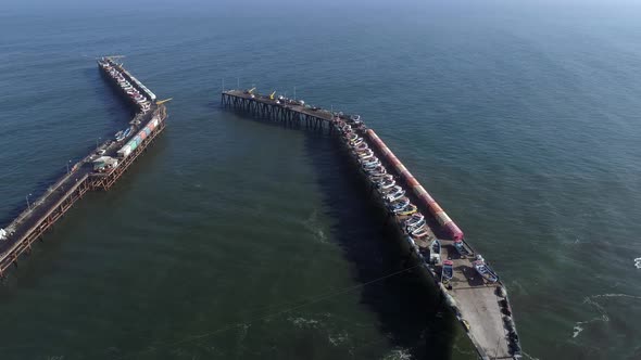 Playa Maguillines Pier With Restaurants And Boats At Daytime In Maule, Chile. - aerial