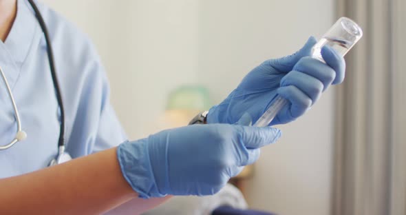 Video of hands of biracial female doctor preparing vaccine