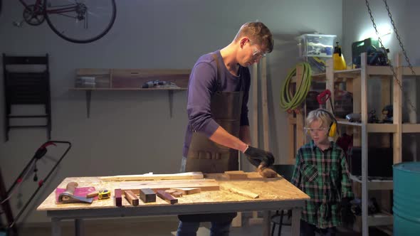 Boy Helps To Put Tools on the Shelf in the Workshop