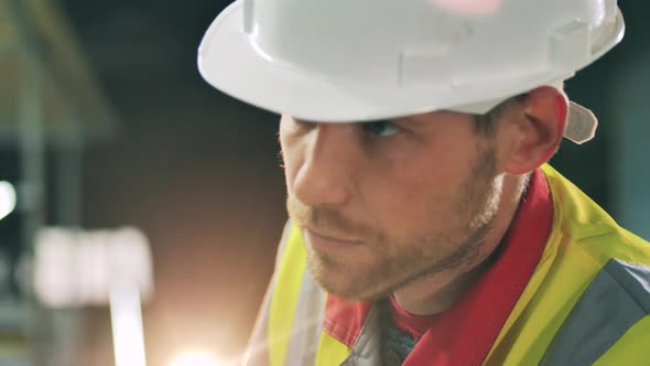 Sideview of Bearded Worker Face at Metal Working Factory