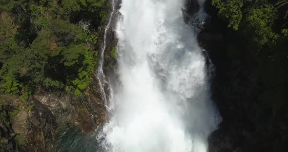 Drone image panning over a waterfall where you can see from the base to where the waterfall is born.