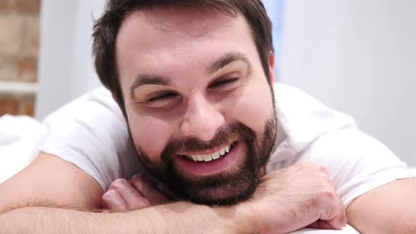 Close Up of Smiling Beard Man Face Lying in Bed