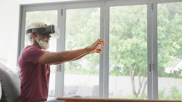 Video of african american senior man using vr headset