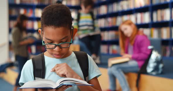 Smart Africanamerican Student Boy Reading Book in Library