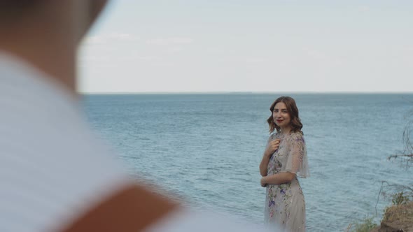 Happy Couple Standing in Front of Each Other at a Distance Sea on the Background