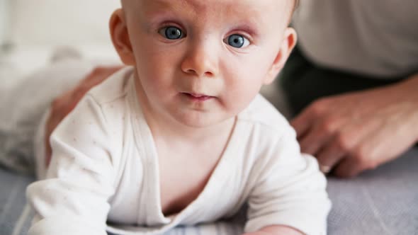 Closeup of Cute Blue Eyed Baby Trying To Crawl