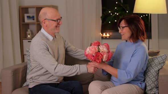 Happy Senior Couple with Bunch of Flowers at Home