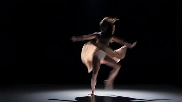 Young Woman Dancer Dancing Contemporary Dance, Jumping and Doing a Split, on Black, Shadow