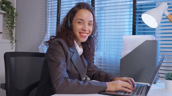 Portrait of Latino beautiful business woman call center use laptop computer and look at camera.
