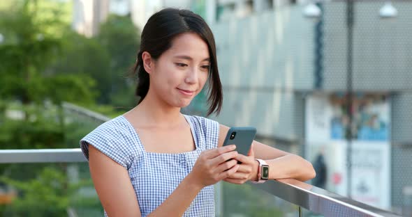 Woman checking on cellphone in the street