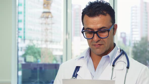 Doctor in Glasses Carefully Examines the Paper