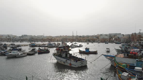 Aerial Push In Shot Of The Fishing Vessels Docked In Marsaxlokk Malta