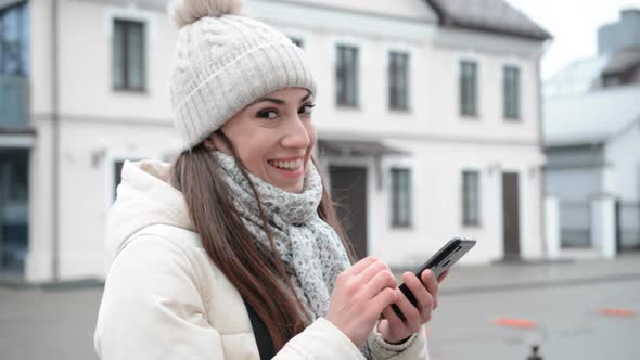 Beautiful and Happy Woman in the Spring Writes a Message on the Phone