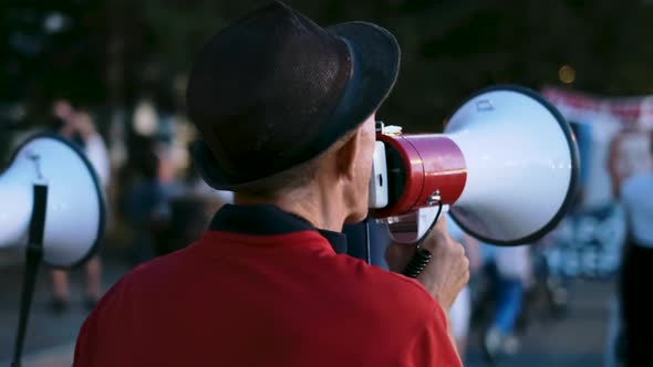 Bullhorn Protester Walks While Speaking in Opposition Demonstration Rally Crowd