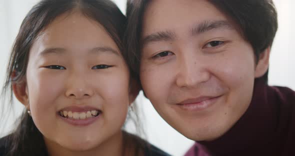 Close Up of Young Asian Couple Smiling at Camera