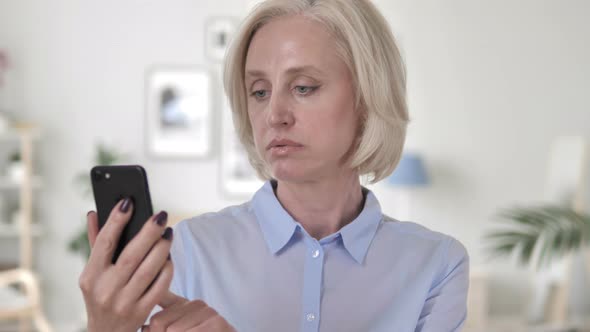 Old Woman Busy Using Smartphone