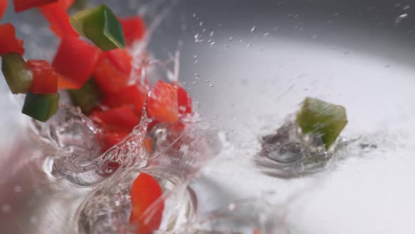 Tossing green and red bell pepper in heated fry pan. Slow Motion.