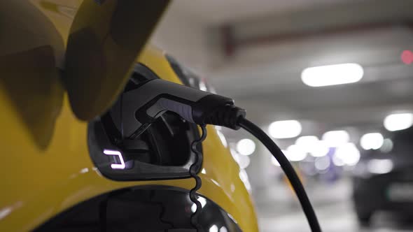 Slow Motion  electric vehicle in underground car park on charge