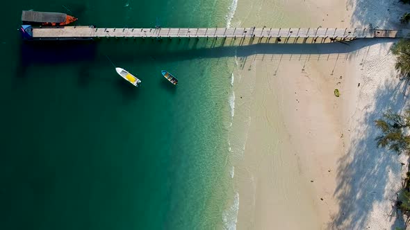 Aerial top down view of beautiful white sand beach and pier on 4k Beach, Koh Rong, Cambodia