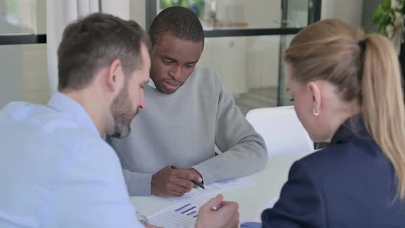 Business People Discussing Documents in Office