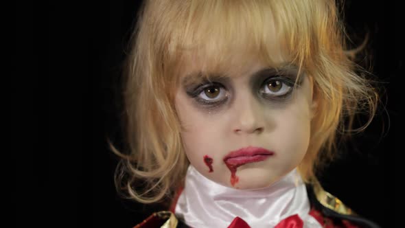 Dracula Child. Girl with Halloween Make-up. Vampire Kid with Blood on Her Face