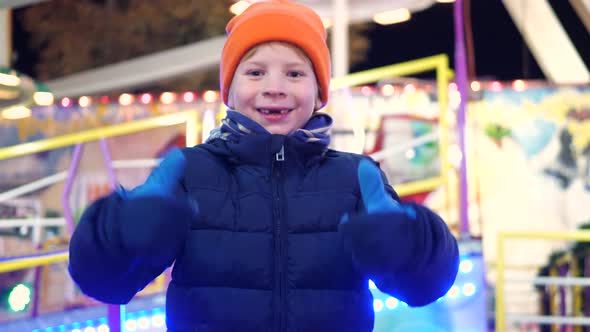 Boy with milk tooth gap is very happy at the Christmas market alt
