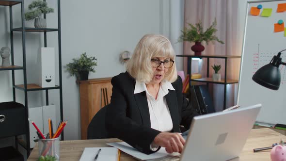 Senior Business Woman Examining Graphs Analyzing Managing Finance Documents Report at Home Office