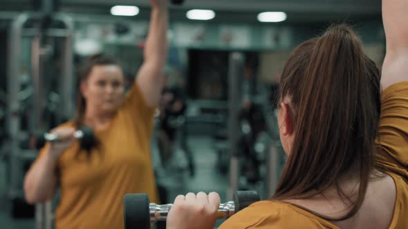 Woman with overweight doing dumbbell exercises. Shot with RED helium camera in 4K.