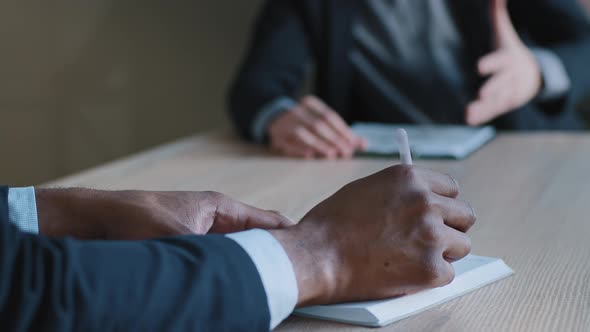 Closeup Male Hands of Multiethnic Business Men Negotiating Discussing Strategy Project Plan Sitting