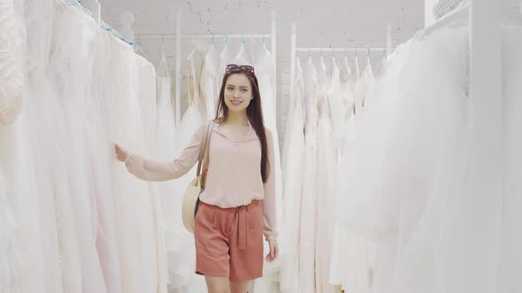 Smiling Woman Going along Wedding Shop