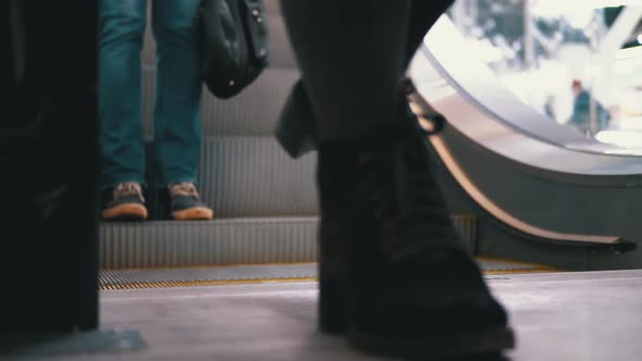 People's Feet Go Down the Escalator Lift in the Mall. Shopper's Feet on Escalator in Shopping Center