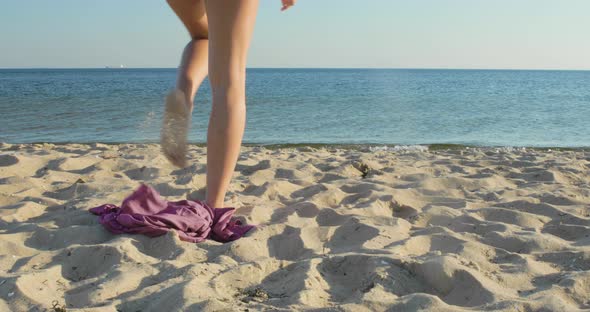 Woman on vacation excitedly runs into the water