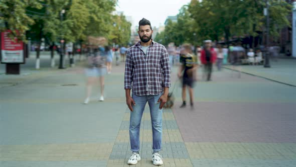 Time Lapse Portrait of Attractive Arab Man Standing Outside in Crowded Street Looking at Camera