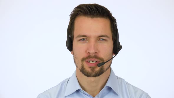 A Young Handsome Call Center Agent Talks To the Camera with a Smile - Closeup - White Screen Studio