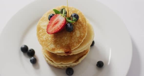 Video of pancakes on plate seen from above on white background