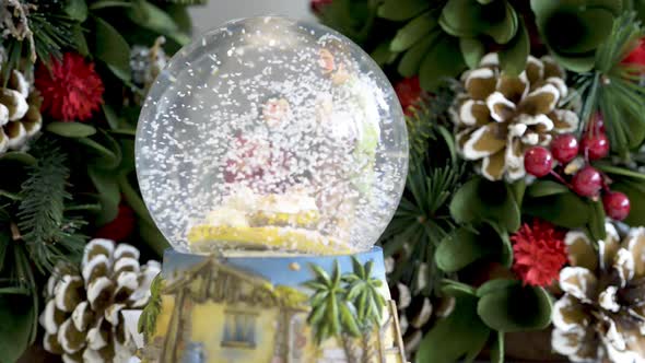 Beautiful snowglobe with child in the manger on Christmas background. Flat plane