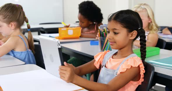 Schoolgirl using digital tablet in classroom