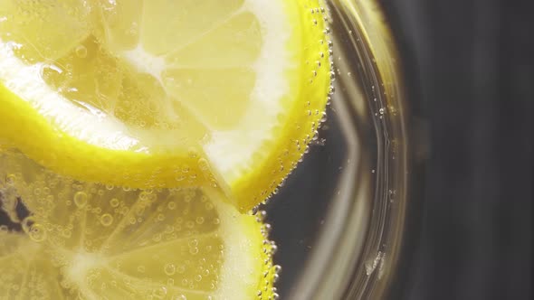 Soda, fresh lemon in glass. Refreshing soda tonic, sparkling water. Lemon wedges, mineral bubbles