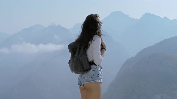Tourist Girl with Backpack at the Mountains