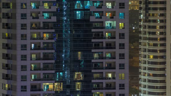 Windows of the Multistorey Building of Glass and Steel Lighting Inside and Moving People Within