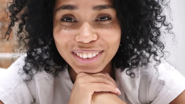 AfroAmerican Woman Lying on Stomach in Bed Smiling Looking in Camera Laughing