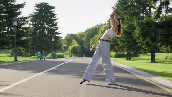 Dancing Young Female Teenager on Road in Park