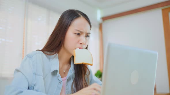 Asian attractive businesswoman hungry eating bread full mouth in hurry time while running business. / Videohive, Stock footage, Technology