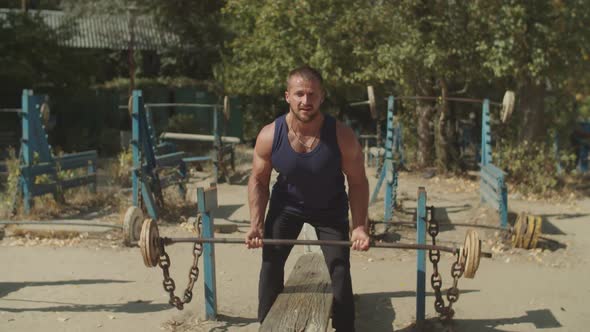 Bodybuilder Workout with Barbell at Outdoor Gym