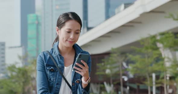 Woman look at mobile phone in city park