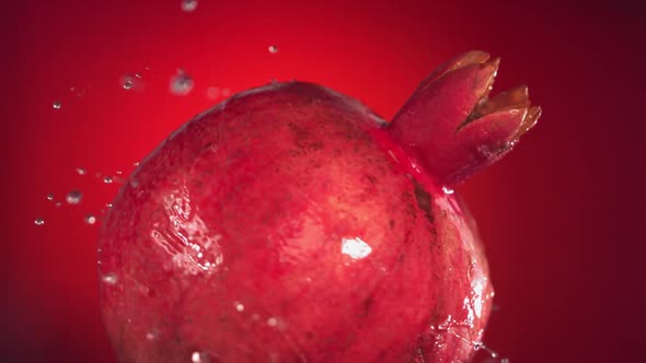 Super Slow Motion Water Drips on Rotating Pomegranate