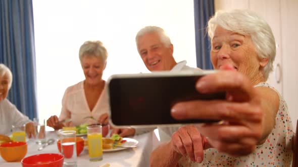 Senior woman taking a selfie with her friends