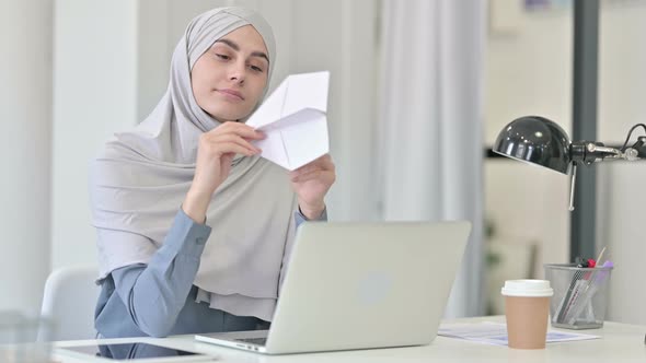 Young Arab Woman with Laptop Flying Paper Plane