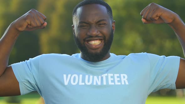 Funny Afro-American Male Volunteer Showing Strong Gesture, Care and Support