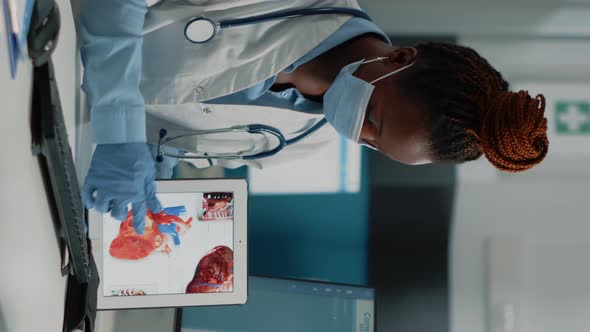 Vertical Video Doctor Pointing at Tablet with Heart Organ on Screen